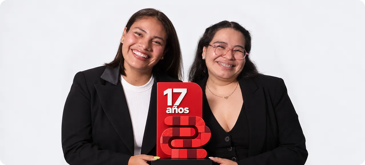 Dos integrantes del equipo sostienen un reconocimiento por los 17 años de CC2México.